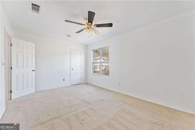 unfurnished bedroom featuring visible vents, a textured ceiling, carpet, and baseboards
