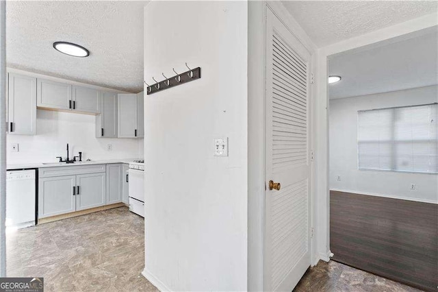 kitchen featuring baseboards, light countertops, a textured ceiling, and stove