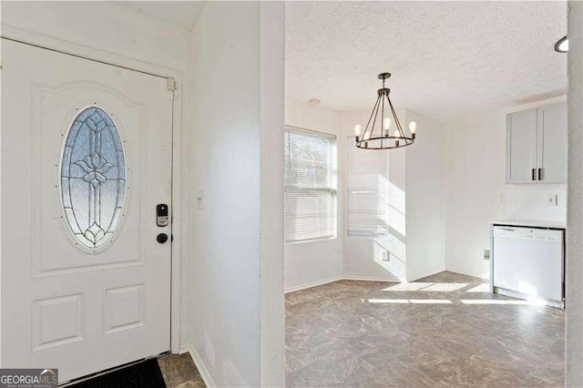 foyer entrance with an inviting chandelier, baseboards, and a textured ceiling