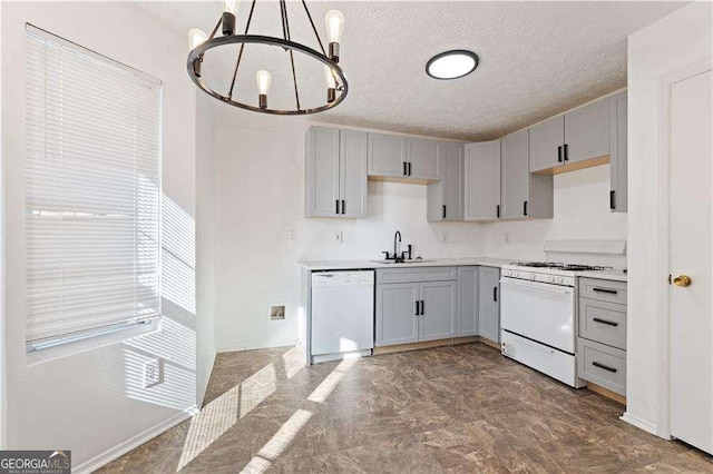 kitchen with white appliances, light countertops, a textured ceiling, a chandelier, and a sink