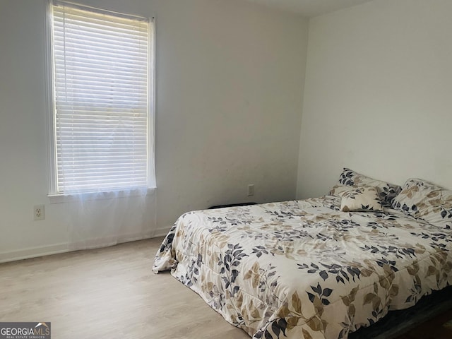 bedroom with baseboards and wood finished floors