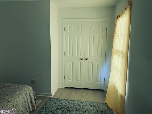 bedroom featuring baseboards, a closet, and wood finished floors