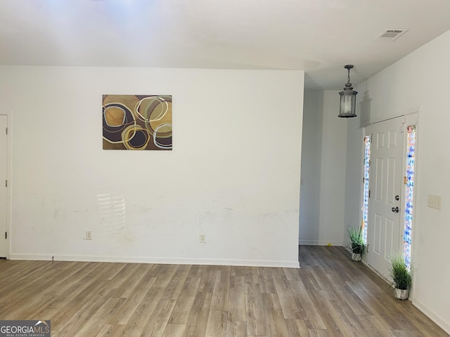 interior space featuring baseboards, light wood finished floors, and visible vents