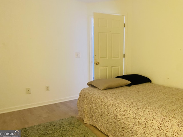 bedroom with baseboards and wood finished floors
