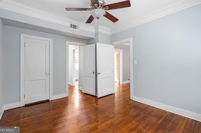 unfurnished bedroom featuring crown molding, ceiling fan, hardwood / wood-style floors, baseboards, and visible vents