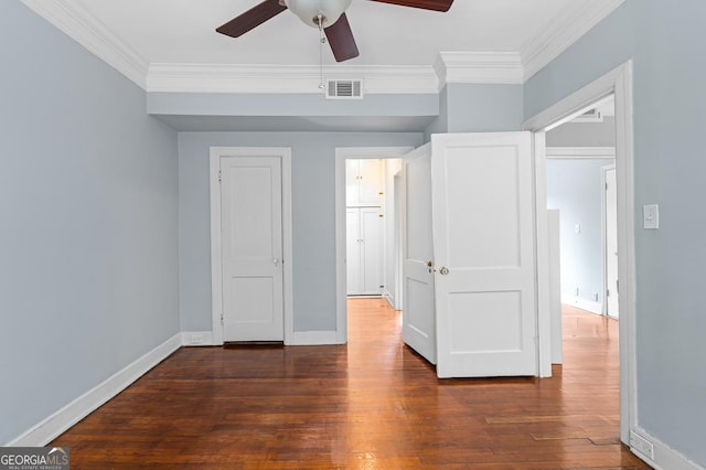 unfurnished bedroom with crown molding, baseboards, visible vents, and dark wood finished floors
