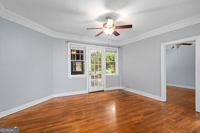 empty room with baseboards, ornamental molding, ceiling fan, and wood finished floors
