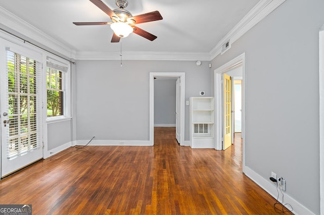 empty room with wood-type flooring, crown molding, ceiling fan, and visible vents