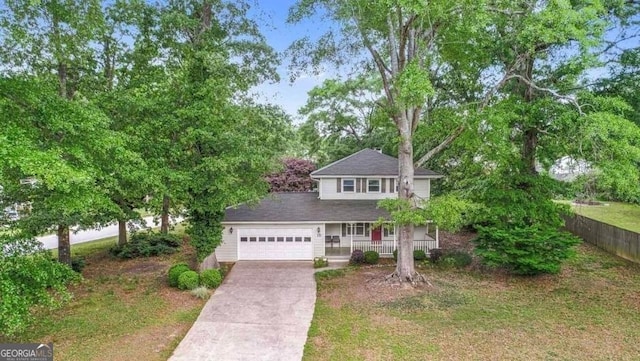 view of front of property with an attached garage, a shingled roof, covered porch, and driveway