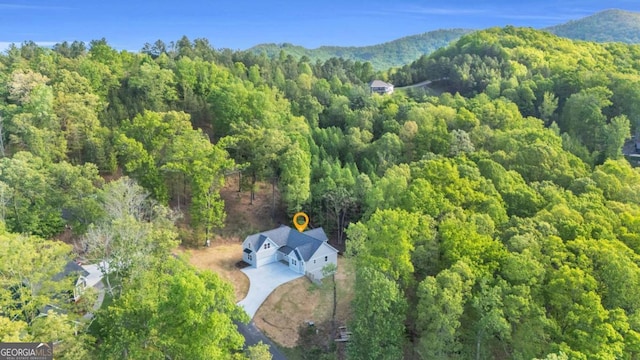 birds eye view of property featuring a forest view and a mountain view