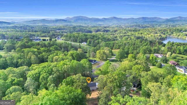 aerial view with a water and mountain view and a view of trees