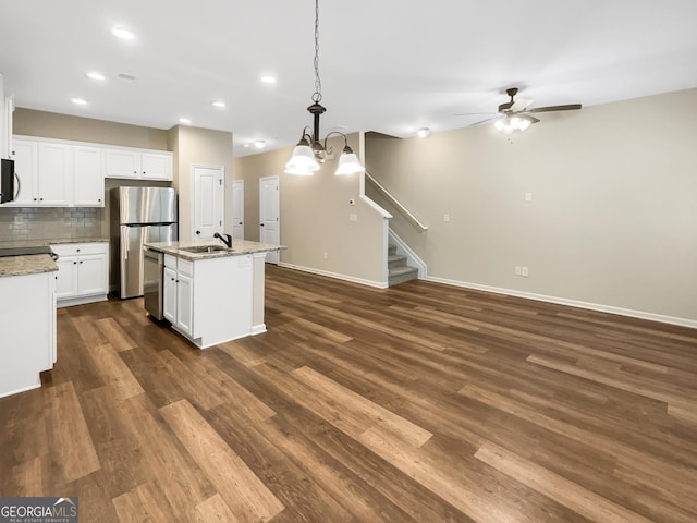 6001 Oak Bend Ct, Riverdale, GA 30296 - kitchen featuring appliances with stainless steel finishes, ceiling fan, a center island with sink, backsplash, and pendant lighting