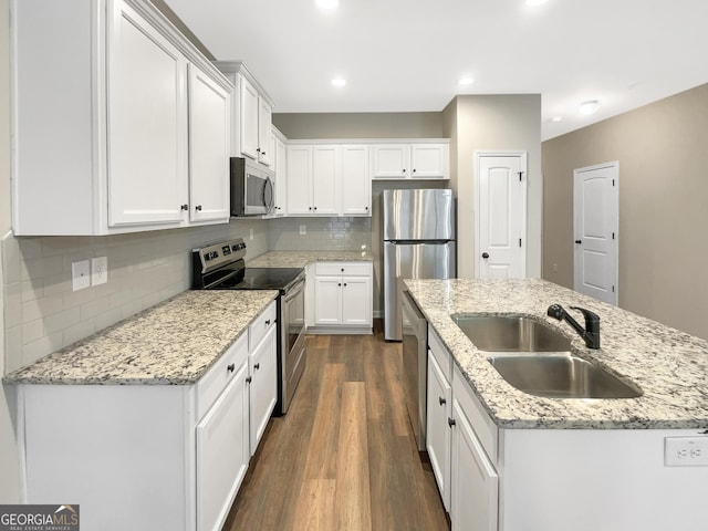 6001 Oak Bend Ct, Riverdale, GA 30296 - kitchen with stainless steel appliances, an island with sink, white cabinetry, dark wood finished floors, and backsplash