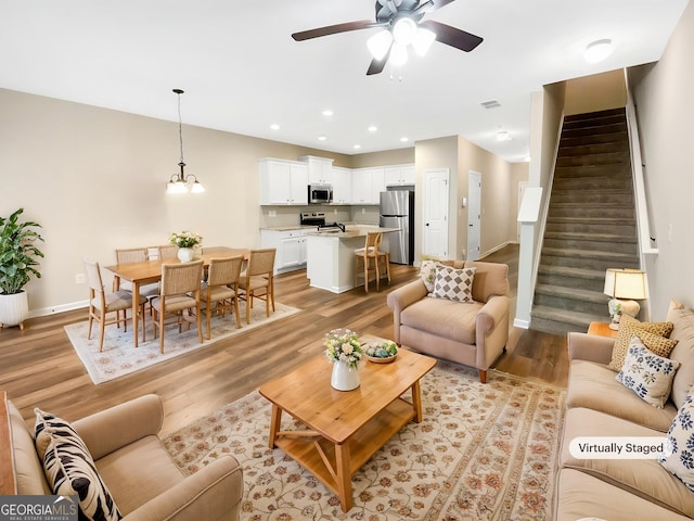 6001 Oak Bend Ct, Riverdale, GA 30296 - living room with stairway, a ceiling fan, light wood-style floors, recessed lighting, and a chandelier