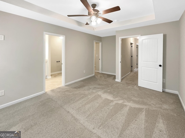 6001 Oak Bend Ct, Riverdale, GA 30296 - unfurnished bedroom featuring a tray ceiling, carpet, connected bathroom, and a ceiling fan