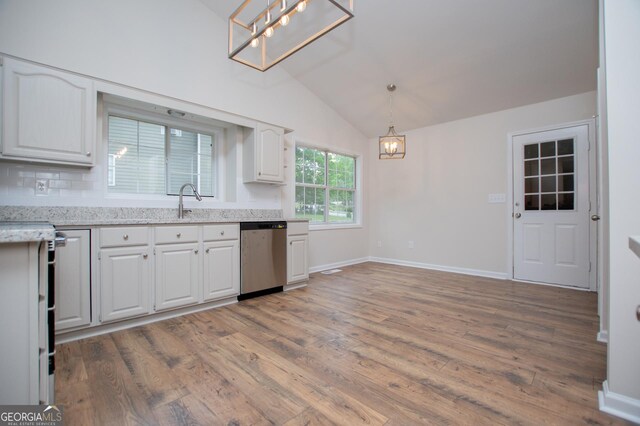 kitchen featuring lofted ceiling, white cabinets, light wood-style flooring, dishwasher, and a notable chandelier