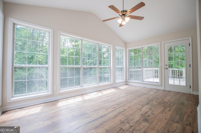 unfurnished sunroom featuring a wooden deck, wood finished floors, and lofted ceiling