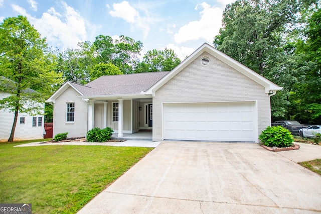 ranch-style home featuring an attached garage, brick siding, a front yard, covered porch, and driveway