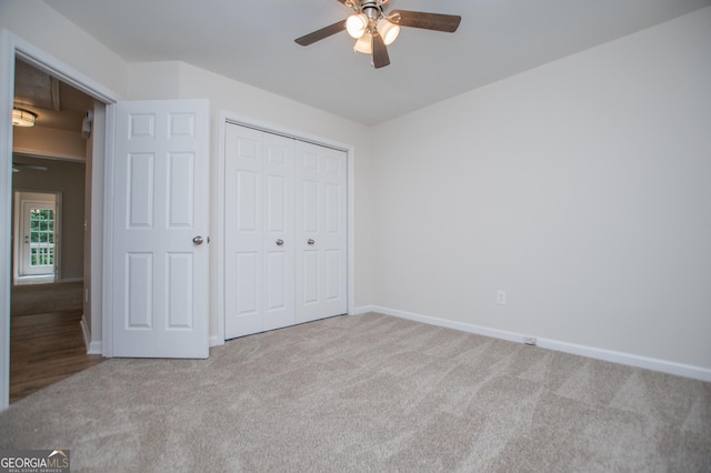 unfurnished bedroom with baseboards, carpet, ceiling fan, and a closet
