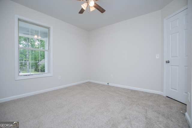 spare room featuring a ceiling fan, baseboards, and carpet