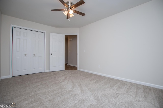 unfurnished bedroom with a closet, baseboards, a ceiling fan, and carpet flooring