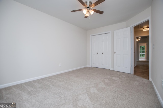 unfurnished bedroom featuring carpet floors, a ceiling fan, baseboards, and a closet