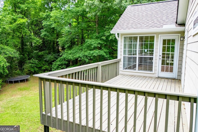 deck with a lawn and a trampoline