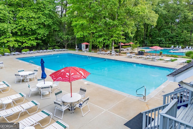 pool with fence and a patio area