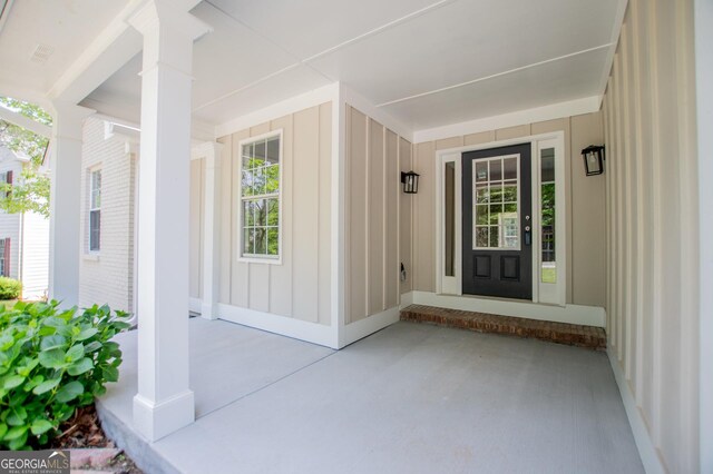 property entrance featuring board and batten siding and covered porch