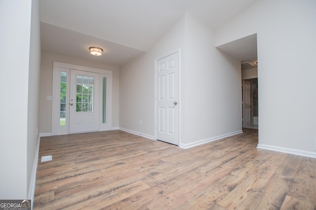 entryway with baseboards, vaulted ceiling, and wood finished floors