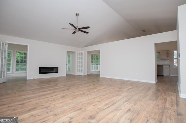 unfurnished living room with a ceiling fan, a glass covered fireplace, plenty of natural light, and wood finished floors