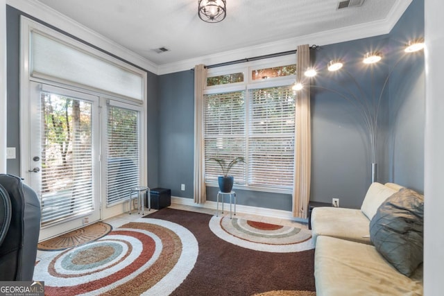 sitting room with visible vents, ornamental molding, and baseboards