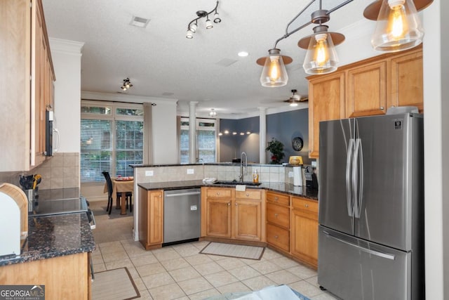kitchen with ceiling fan, a sink, stainless steel appliances, a peninsula, and tasteful backsplash