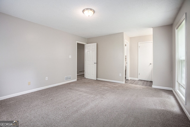 unfurnished bedroom featuring visible vents, carpet flooring, and baseboards