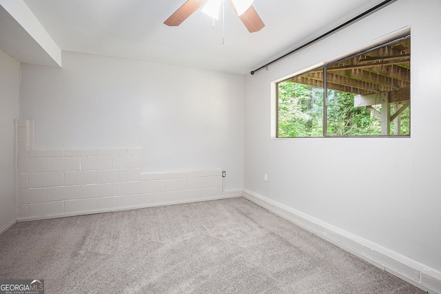 carpeted empty room featuring baseboards and ceiling fan