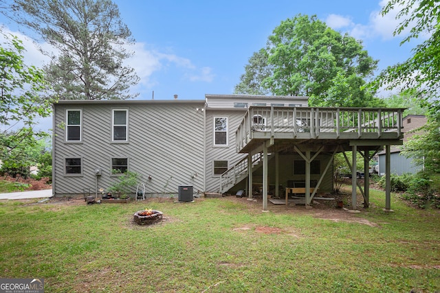 back of property featuring a fire pit, a wooden deck, a yard, and stairway
