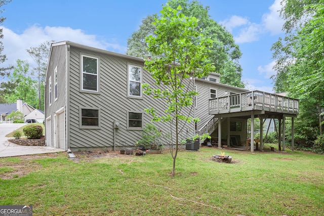 rear view of property featuring stairway, a deck, central AC, and a yard