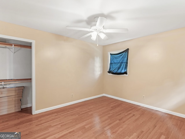 unfurnished bedroom with light wood-style floors, baseboards, and a ceiling fan
