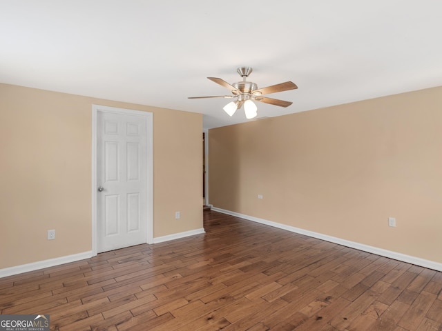 spare room with baseboards, ceiling fan, and wood finished floors