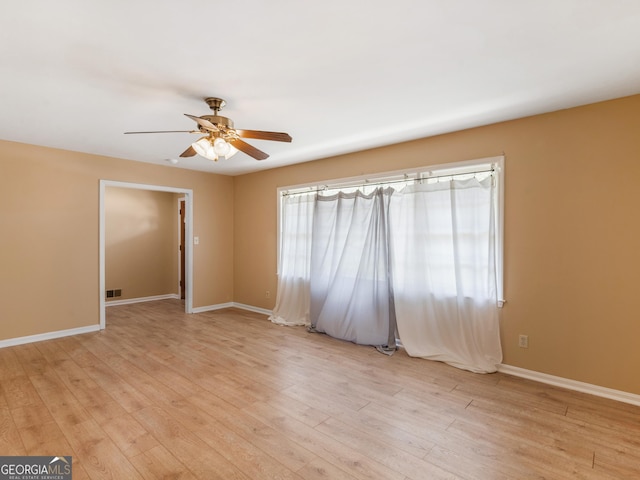 unfurnished room with a ceiling fan, baseboards, visible vents, and light wood finished floors