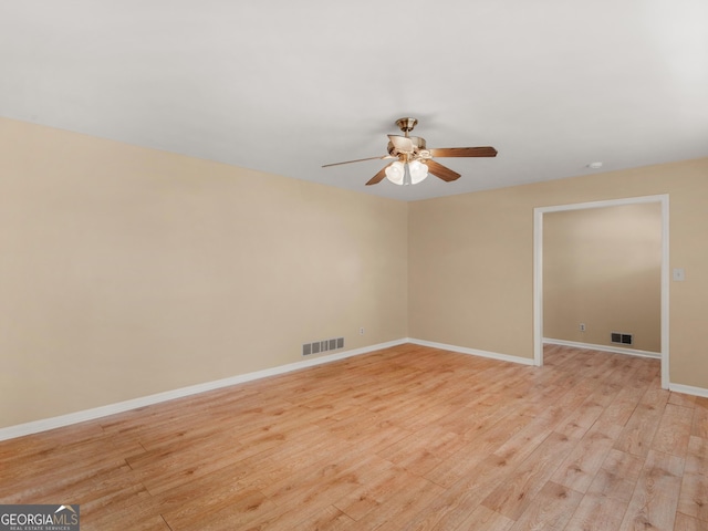 unfurnished room with baseboards, a ceiling fan, light wood-type flooring, and visible vents
