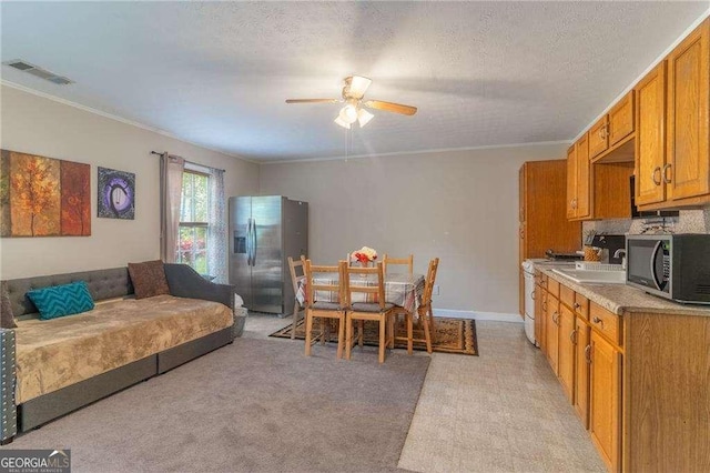 204 Queensbury Ct, Acworth, GA 30102 - kitchen featuring ceiling fan, appliances with stainless steel finishes, light countertops, visible vents, and ornamental molding