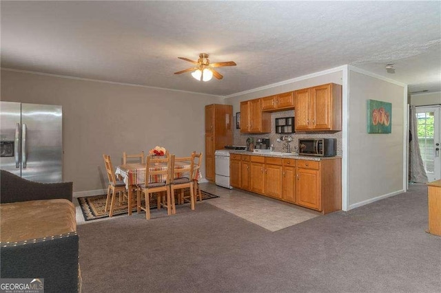 204 Queensbury Ct, Acworth, GA 30102 - kitchen with crown molding, light carpet, ceiling fan, light countertops, and appliances with stainless steel finishes