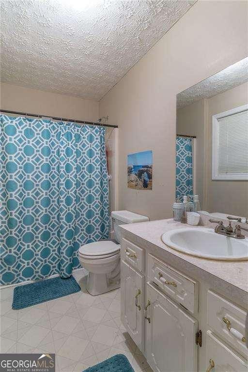 204 Queensbury Ct, Acworth, GA 30102 - bathroom with toilet, a textured ceiling, curtained shower, and vanity
