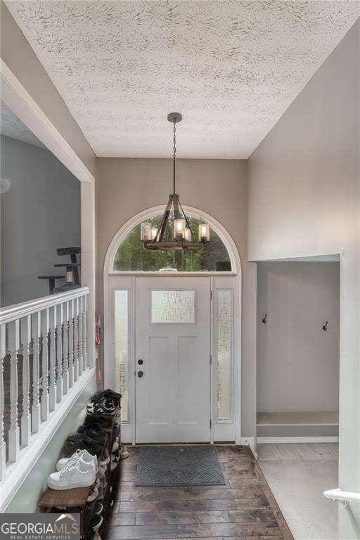 204 Queensbury Ct, Acworth, GA 30102 - foyer entrance with a textured ceiling, an inviting chandelier, and wood finished floors
