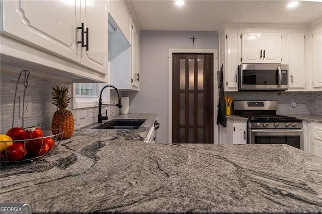 204 Queensbury Ct, Acworth, GA 30102 - kitchen with a sink, backsplash, stainless steel appliances, and white cabinetry