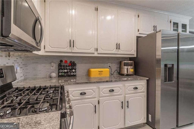 204 Queensbury Ct, Acworth, GA 30102 - kitchen with white cabinetry, light stone countertops, appliances with stainless steel finishes, and decorative backsplash