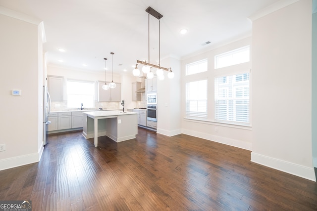 915 Katie Kerr Dr, Decatur, GA 30030 - kitchen with ornamental molding, a kitchen island, freestanding refrigerator, and light countertops