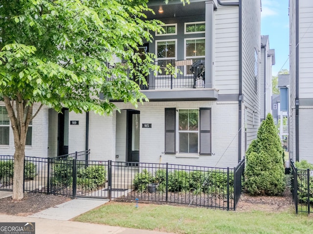 915 Katie Kerr Dr, Decatur, GA 30030 - view of front facade featuring brick siding, a fenced front yard, a balcony, and covered porch