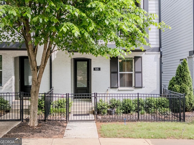 915 Katie Kerr Dr, Decatur, GA 30030 - view of exterior entry featuring brick siding, fence, and a gate